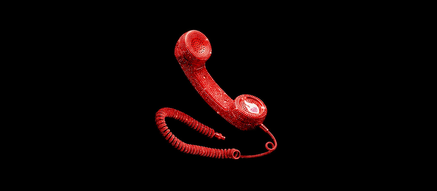 Bright red retro telephone handset completely covered in sparkling rhinestones, featuring a classic coiled cord and the iconic Cook For Your Crush logo, set against a solid black backdrop.